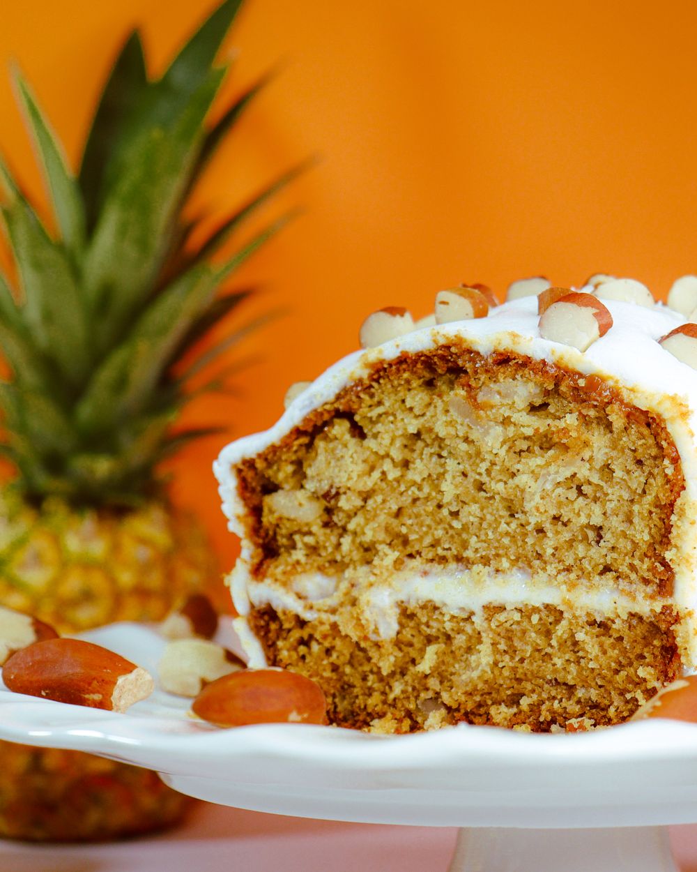A golden pineapple layer cake with cream filling and macadamia nuts, baked from scratch